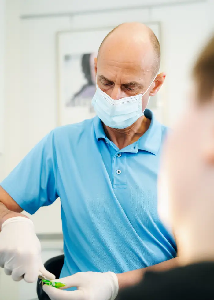 Dr. Ralf Schneevoigt behandelt einen Patienten in der Praxis für Kieferorthopädie am Fetscherplatz in Dresden.
